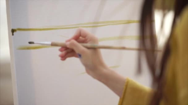 Den unga konstnären målar de första slag av färg på duken för stilleben — Stockvideo