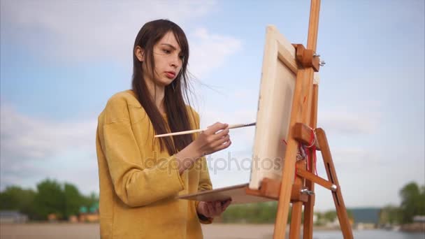 Pittura ad aria piacevole. Giovane artista che lavora su cavalletto esterno — Video Stock