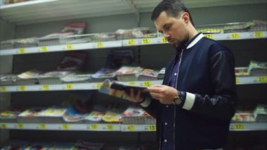 Orta yaşlı bir adam deposundaki bir moda dergisinin resimlere görünüyor