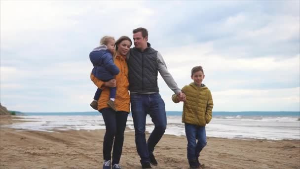 快乐的父母和两个孩子在海边散步 — 图库视频影像