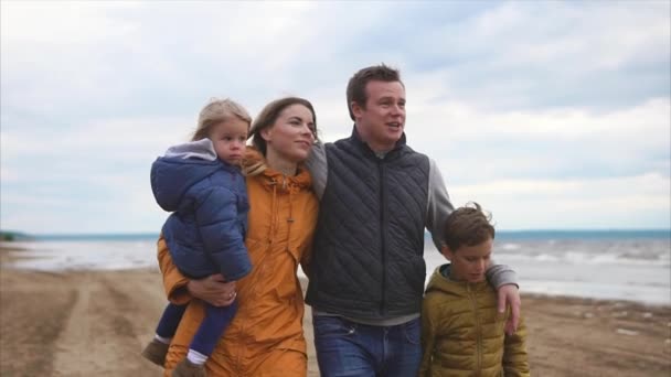 Famiglia felice e amichevole sta camminando con i loro figli sulla spiaggia il giorno libero — Video Stock