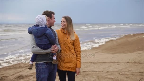 Женатая пара с ребенком стоит на пляже и наслаждается выходными — стоковое видео