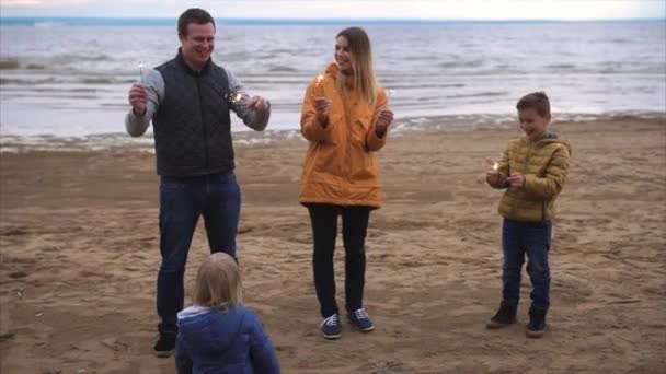 Familj med tomtebloss vid havet — Stockvideo