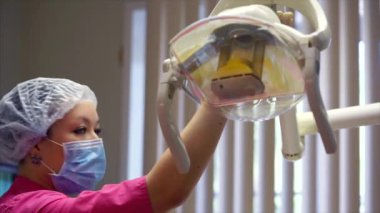 Kadın doktor tıbbi lamba koruyucu maske kurma