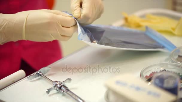 Zahnarzt öffnet Packung mit sterilen zahnärztlichen Instrumenten — Stockvideo