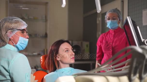 Kieferorthopäde Arzt sagt dem Patienten, was er mit Zähnen in der Zahnheilkunde machen wird — Stockvideo