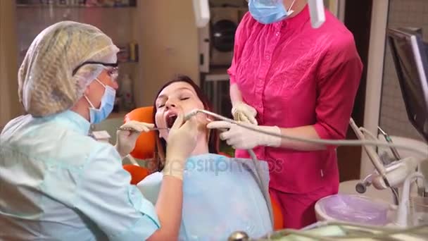 Orthodontist arts behandelt een patiënt van een tandheelkundige kliniek die kwam voor mondverzorging — Stockvideo