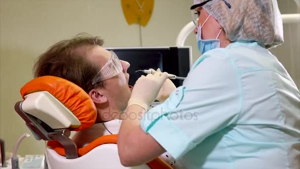 Dentista mulher fazendo procedimento de tratamento dentário. Assistente ajudando-a — Vídeo de Stock