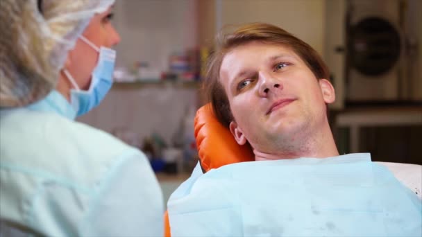 Стоматолог каже пацієнту, що йому потрібно очистити карієс — стокове відео