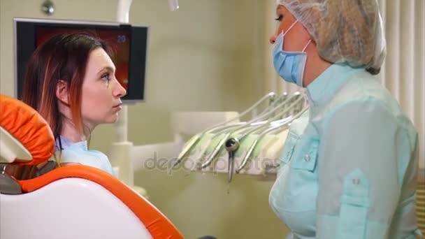 Dentysta informuje pacjenta o instrumentach, na której on będzie leczyć zęby — Wideo stockowe