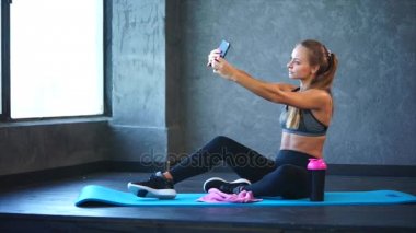Spor salonunda bir cep telefonunda selfie iyi bir rakam ile genç bir kız yapar