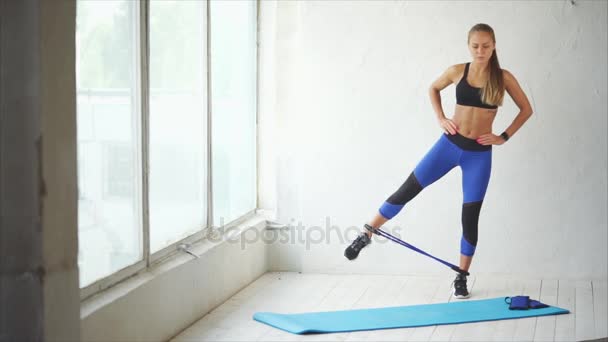 Fitness trenér dělá strečink svalů boční noze pomocí sportovní postroj — Stock video