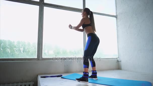 Привлекательная женщина делает упражнения на мышцах ягодиц в спортивном клубе — стоковое видео