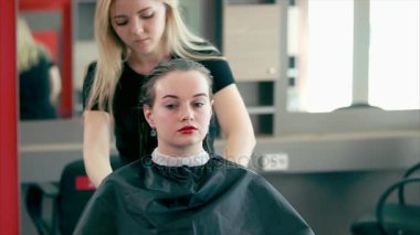 Bir saç stilisti saçını bir saç kurutma makinesi ile kuru için ıslak saçları araması yapıyor