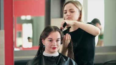 Bir saç stilisti saçını bir saç kurutma makinesi ile kuru için ıslak saçları araması yapıyor