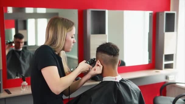 Jeune homme client et femme coiffeuse. Barber coupe les cheveux — Video