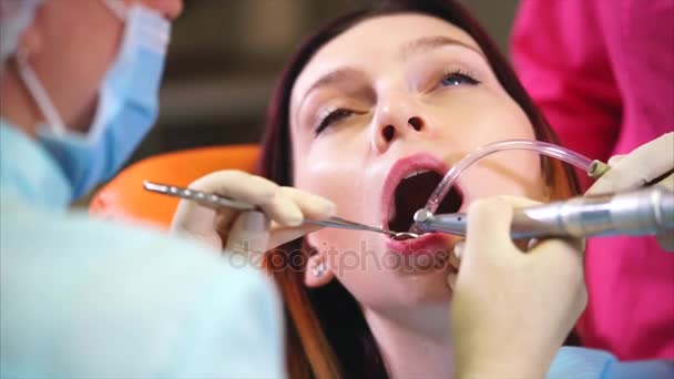 Un médico de la clínica dental lava los dientes de los pacientes con agua y un espejo — Vídeo de stock