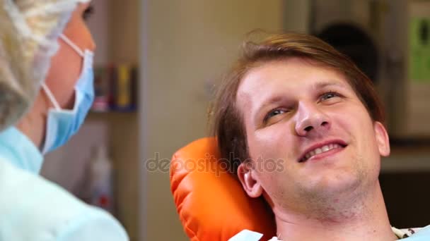 Dentista falando com o paciente homem após o exame — Vídeo de Stock