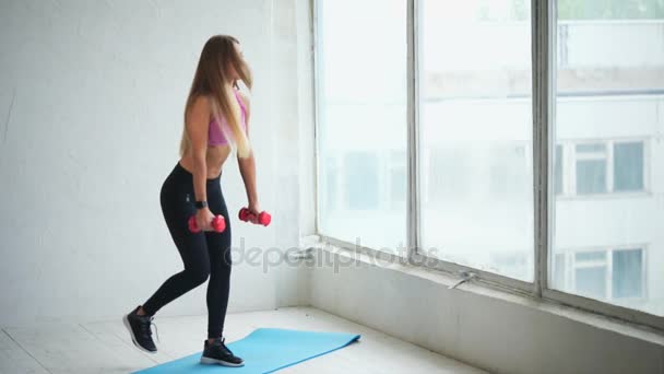Fitness Club dumbbells ile derin ağız kavgası yaparken genç fitness eğitmeni — Stok video