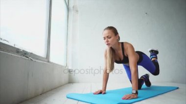 Genç ve atletik kız kalça güçlendirmek için bacaklar ile etkin bacaklar yapar