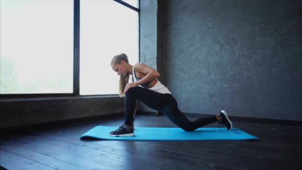 Fiatal fitness nő csinál lábak nyújtás. Jelenet az edzőteremben. Nő a Sportruházat — Stock videók