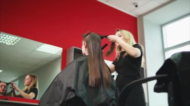 Güzellik Salonu olarak uygulaması yoluyla giden bir genç saç stilisti ıslak saç tarak