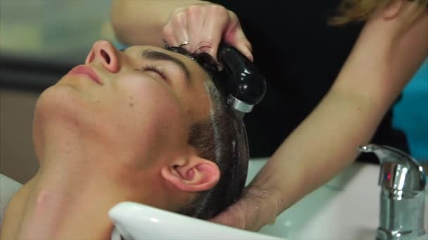 A lavar a cabeça numa barbearia. masculino clientes cabelo chegando lavado — Vídeo de Stock