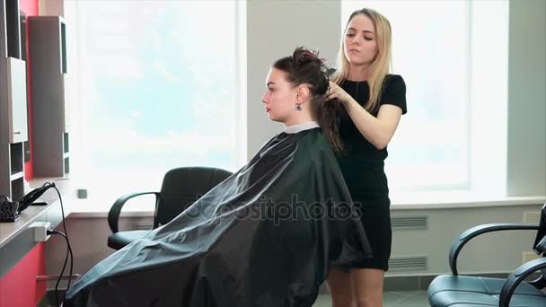 O cabeleireiro belisca o cabelo molhado para secá-los em um salão de beleza — Vídeo de Stock