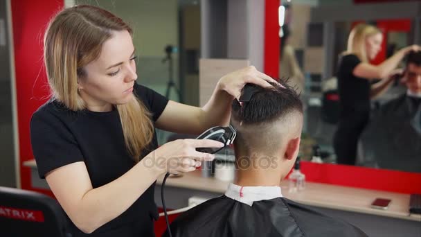 Friseurin bei der Arbeit. sie schneidet die Haare per Haarschneidemaschine — Stockvideo