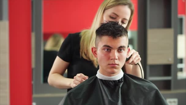 O homem está esperando a mudança de imagem, o cabeleireiro está cortando cabelo na cabeça — Vídeo de Stock