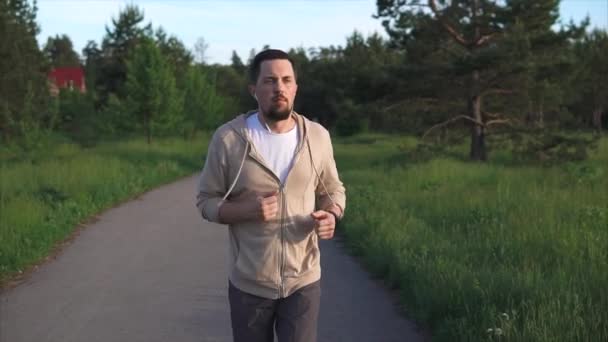 L'homme qui pratique la course sportive se prépare pour un sprint dans le parc — Video