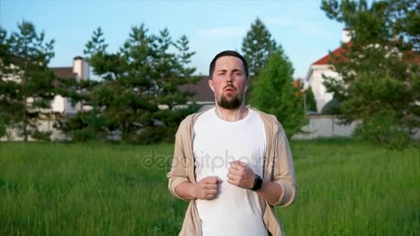 Взрослый мужчина, который активно бегает по парку летом — стоковое видео
