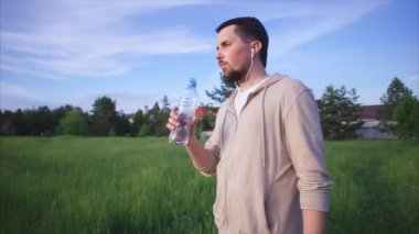 Plastik şişe doğada bir spor takım elbise içme suyu konsantre bir adam