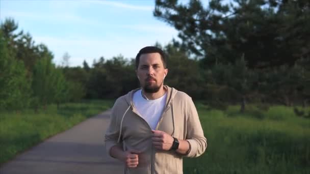 L'homme qui pratique la course sportive se prépare pour un sprint dans le parc — Video