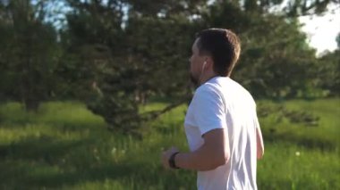 Parkta koşu ve müzik dinleme yapan erkek. Sağlık