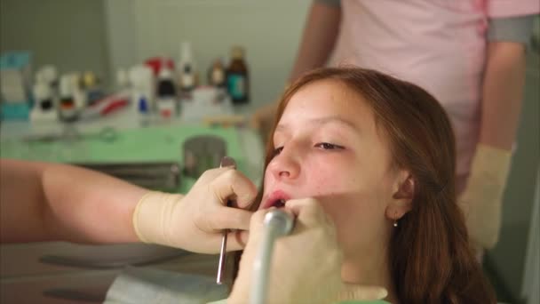 Processus de blanchiment des dents dans l'armoire dentaire. Jeune fille patient — Video
