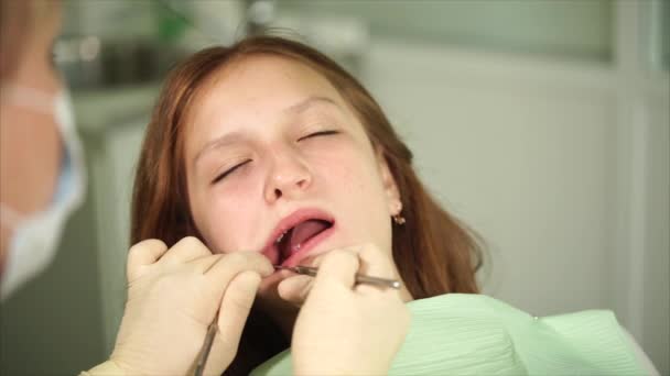 Ortodon revisa los dientes de un adolescente que ha venido a la clínica para recibir tratamiento — Vídeo de stock