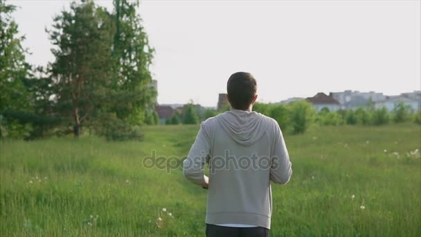 Un joven corriendo en el parque en la pista. Deporte y estilo de vida saludable — Vídeos de Stock