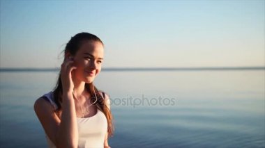 Genç güzel kadın bir kulaklık kullanarak müzik dinlemek.