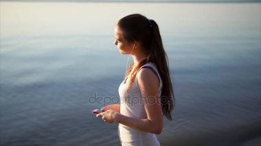 Genç kadın bir kulaklık kullanarak müzik dinlemek mutlu. Yavaş yavaş dans.