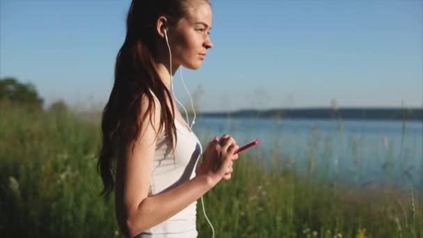 Jeune femme utilisant son smartphone profitant de la nature . — Video