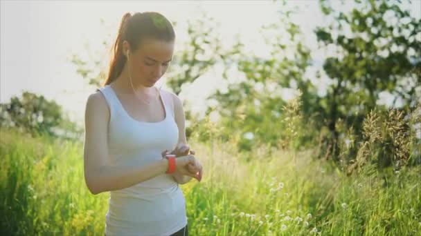 Mujer joven usando relojes inteligentes afuera en el parque . — Vídeo de stock