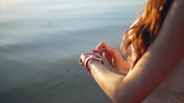 Nära upp skott av kvinna händer använder smarta klockor på stranden nära havet. — Stockvideo