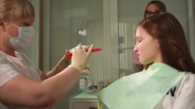 Özel klinik ortodontist bir fırça ile diş fırçalama işlemini gösterir