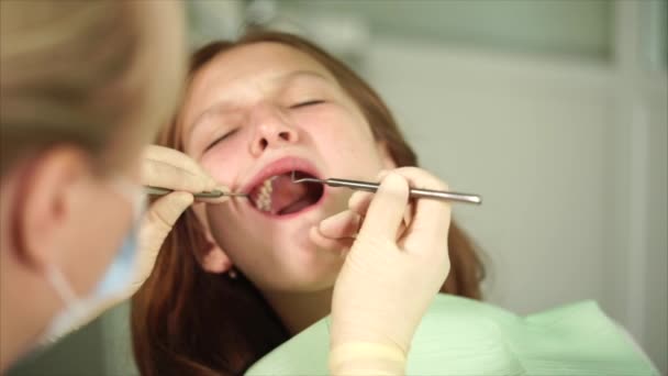 Orthodon controlla i denti di un adolescente che è venuto in clinica per il trattamento — Video Stock