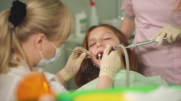 一位做一个少年在一间牙科诊所在刷牙牙医 — 图库视频影像