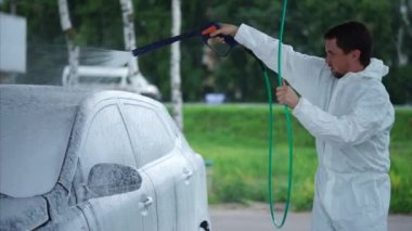 Genç çamaşır arabası araba yıkama Self-Servis köpük sprey kullanarak adam..