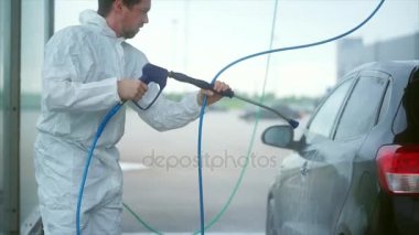 Genç Beyaz adam arabasını yıkar. Araba yıkama Self-Servis. Köpük yıkama off.