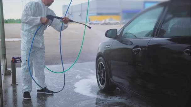 Man zijn auto met verneveld water wassen. Car wash selfservice. — Stockvideo