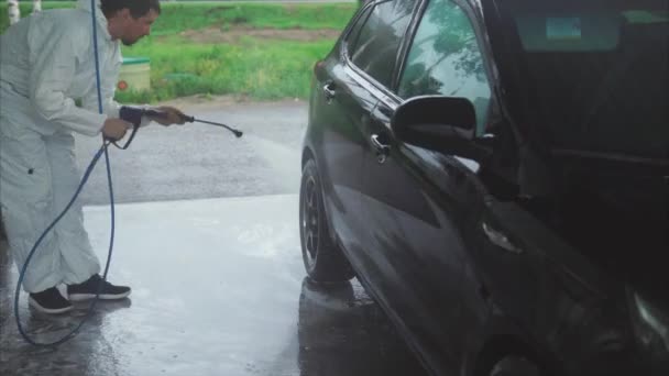 Man zijn auto met verneveld water wassen. Car wash selfservice. — Stockvideo